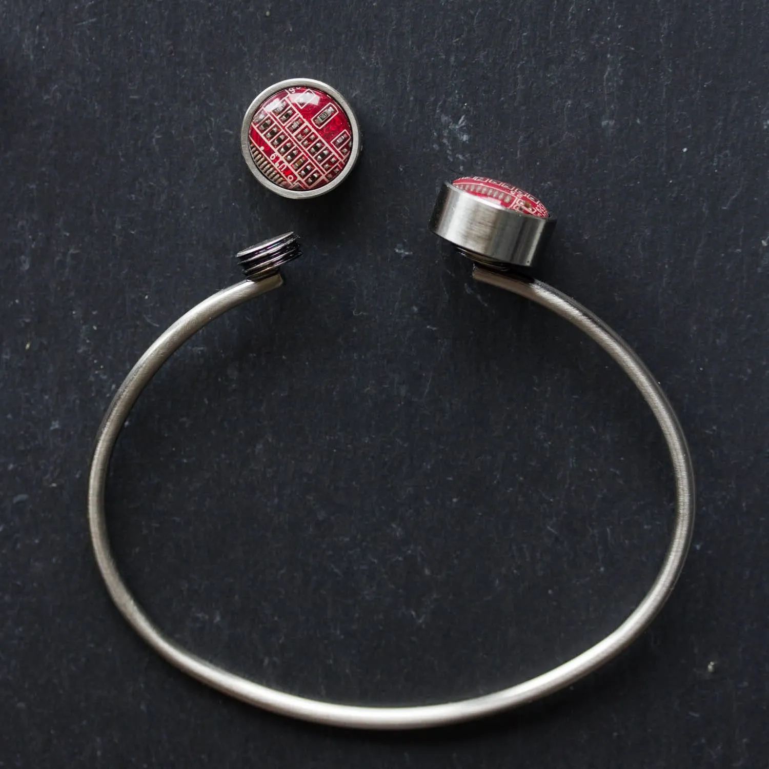 Bangle bracelet with interchangeable buttons